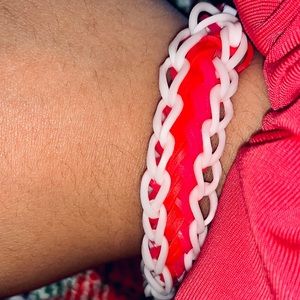 A rainbow loom with a white border and pink, red